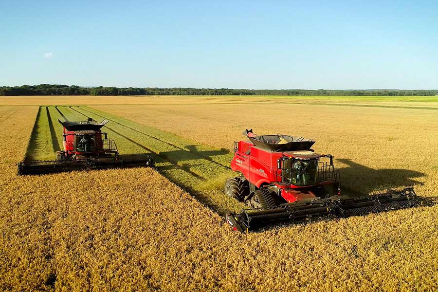 red tractors harvesting field