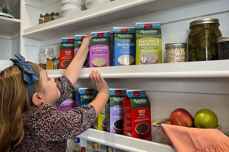 little girl grabbing rice package out of pantry