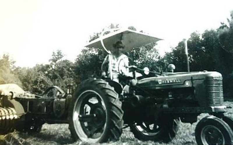 historical black and white image of man on tractor