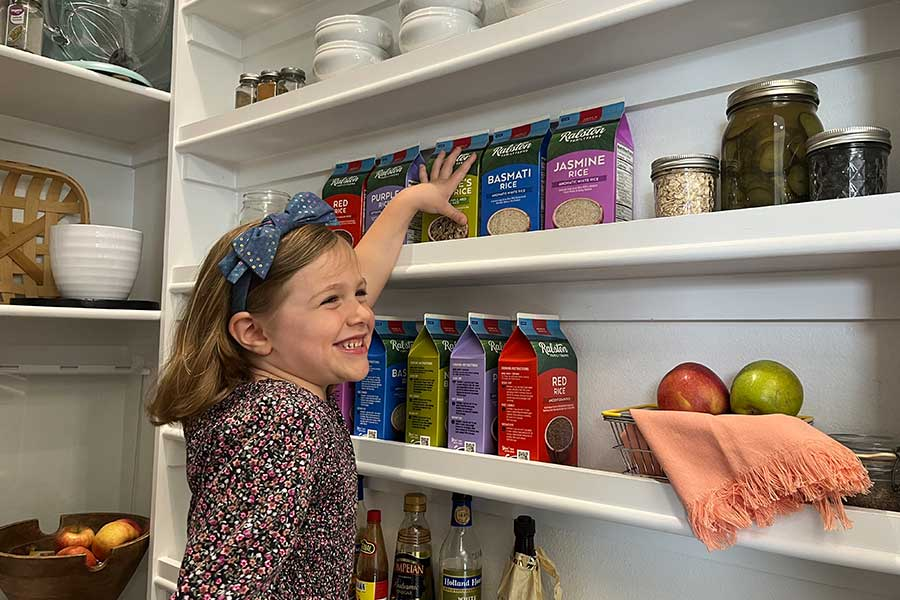 little girl reaching happily in pantry